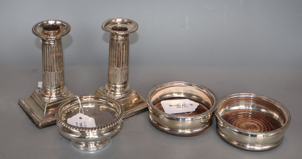 A pair of modern silver wine coasters, a pair of Victorian Doric column dwarf candlesticks (a.f.) and a George IV silver salt